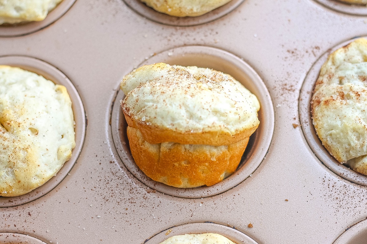 apple dumpling being removed from a muffin tin 