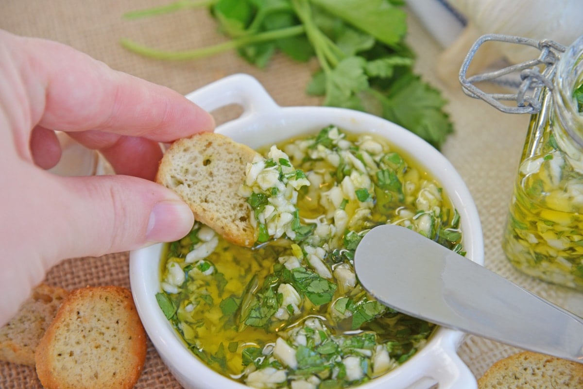 dipping crostini in garlic relish 