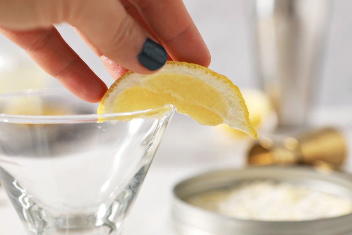 running lemon along the rim of a martini glass 