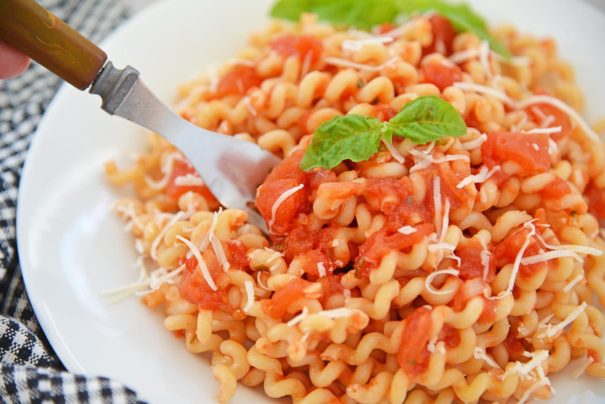 fork digging into a bowl of pomodoro on pasta 