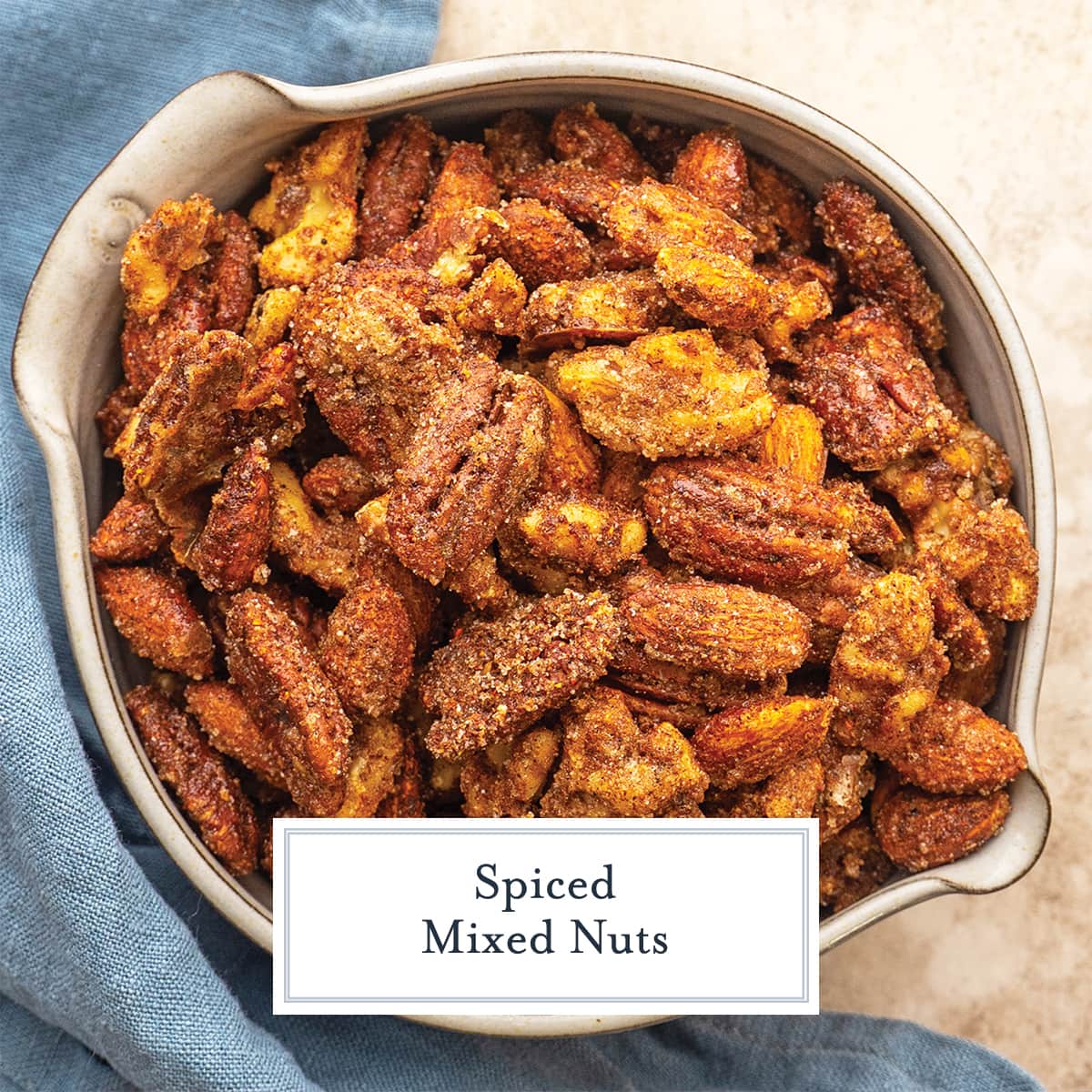 overhead of spiced nuts in a bowl with blue linen