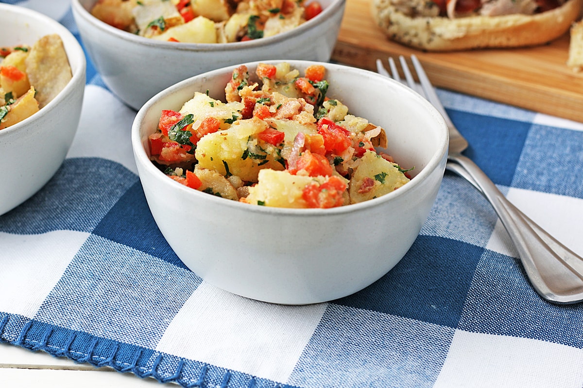 bacon mustard potato salad in a small white bowl 