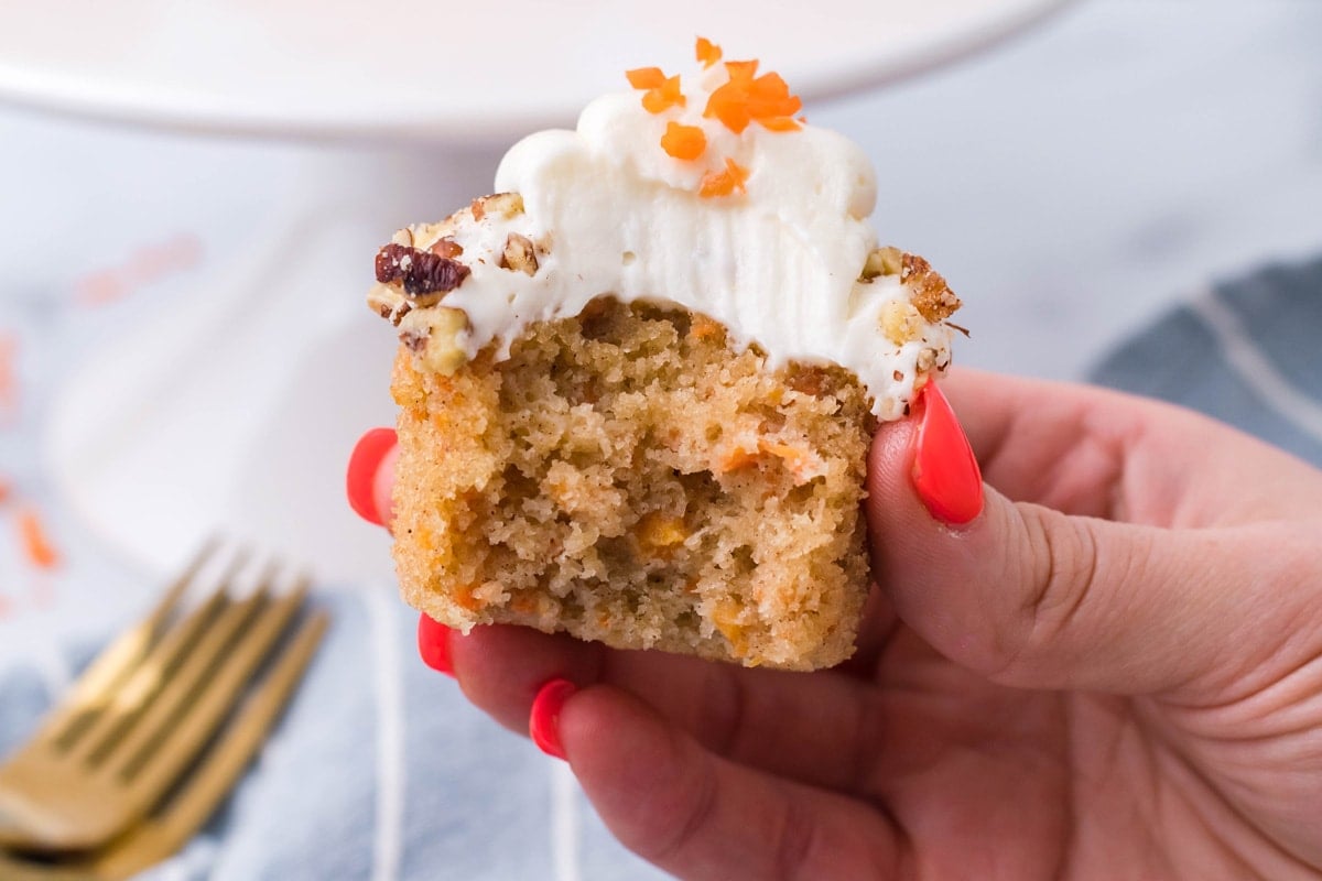 hand holding a cupcake cut in half 