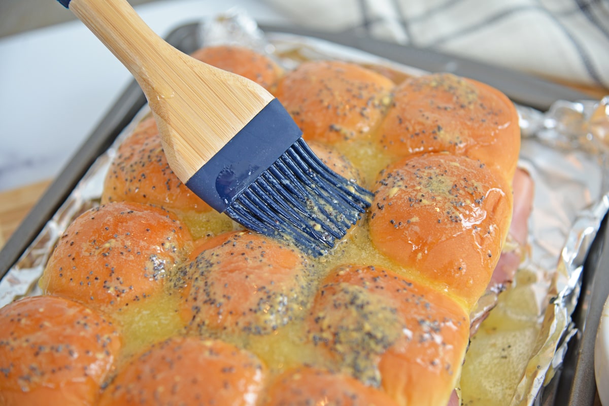 basting butter over ham and cheese sandwiches 