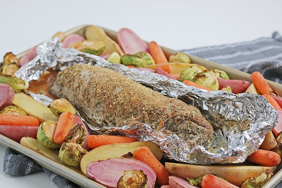 baked tenderloin in aluminum foil with cooked veggies 