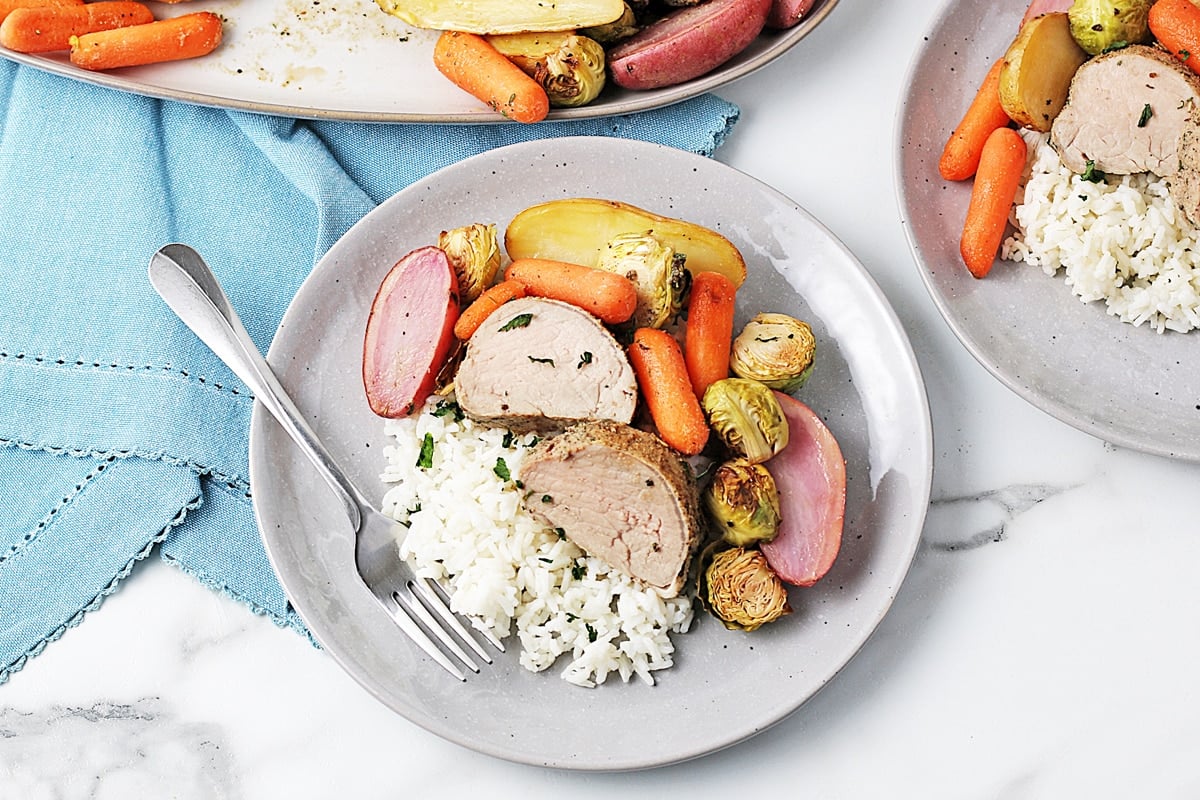 overhead of pork tenderloin medallions with potatoes, carrots and brussels sprouts 