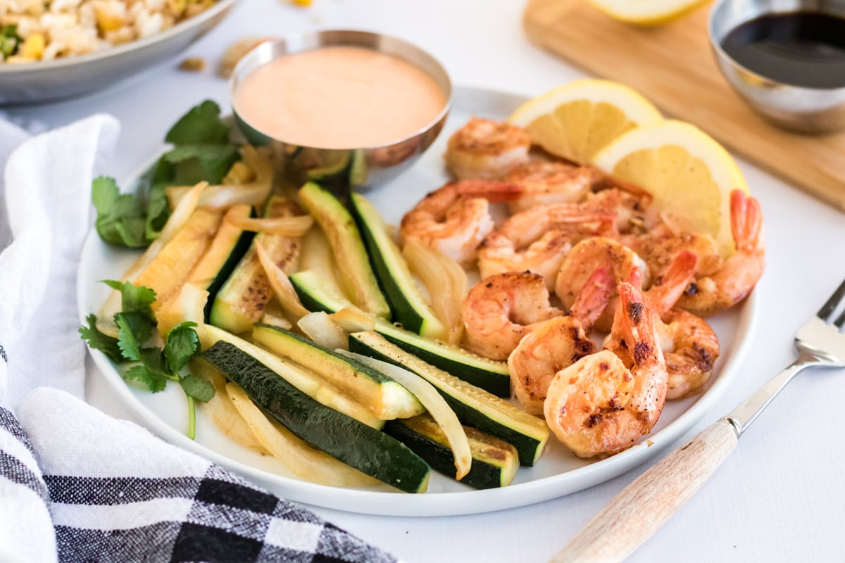 plate of hibachi shrimp, vegetables and dipping sauce