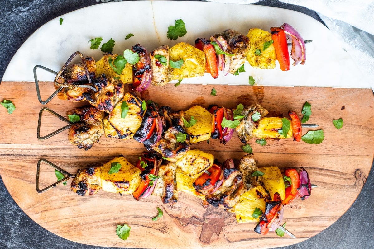 chicken skewers on a wood cutting board