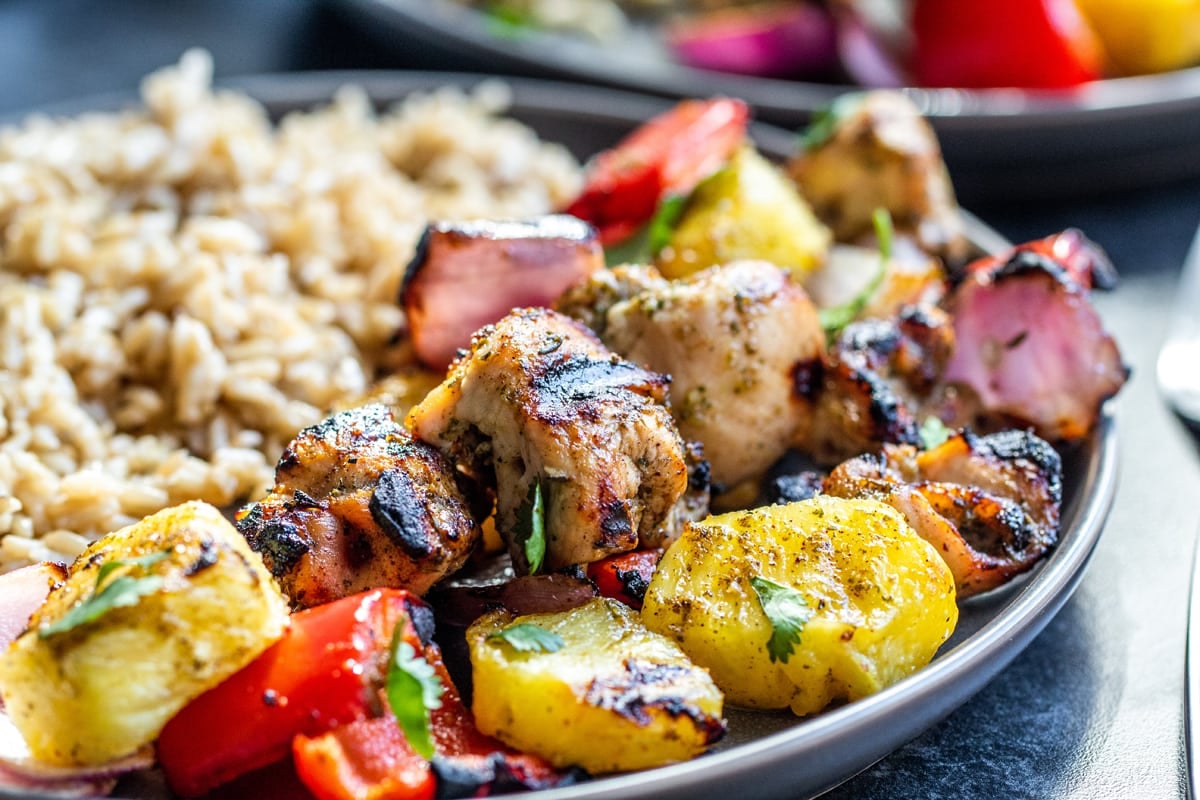 close up of grilled chicken skewers and rice 