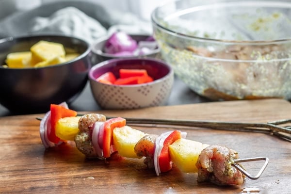 skewering chicken and veggies onto a kabob