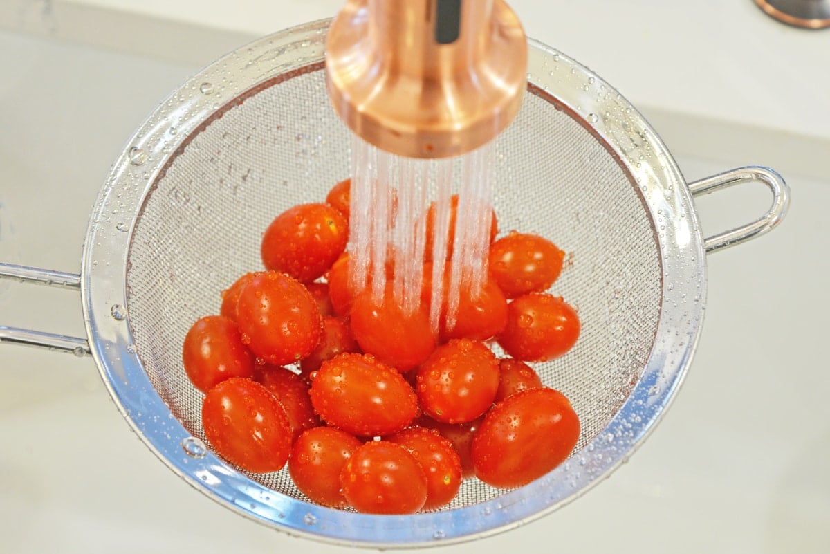 washing tomatoes in a colander 