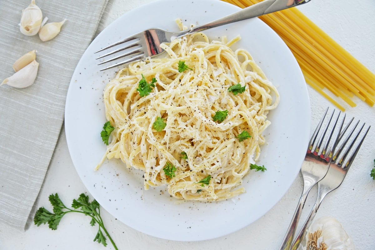 garlic parmesan linguine in a white serving bowl  