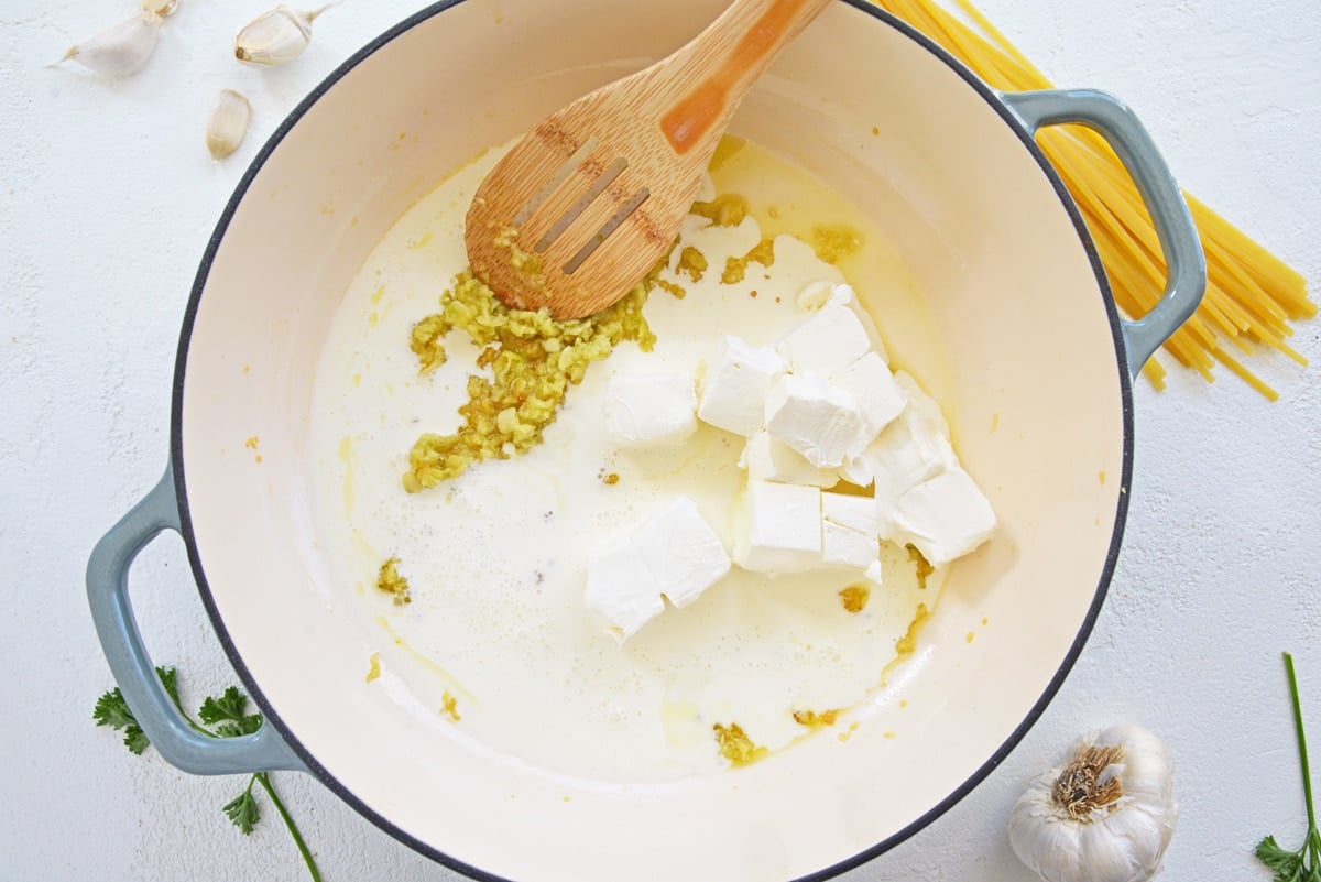 dutch oven with cream cheese, milk and garlic