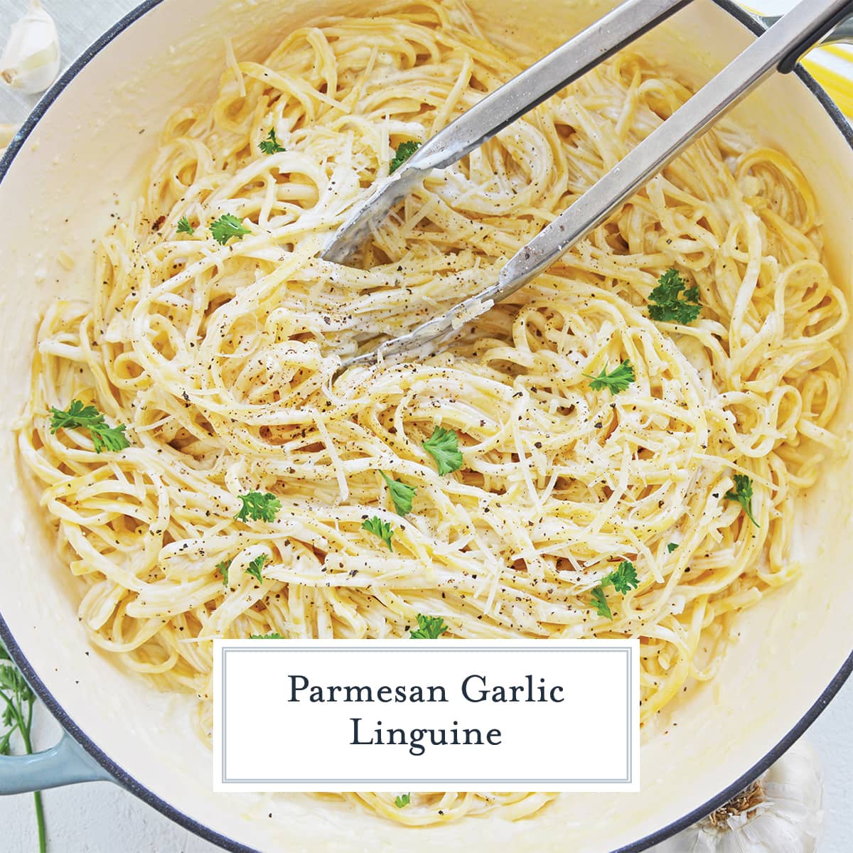 overhead of pasta in a cream sauce in a pot with tongs 