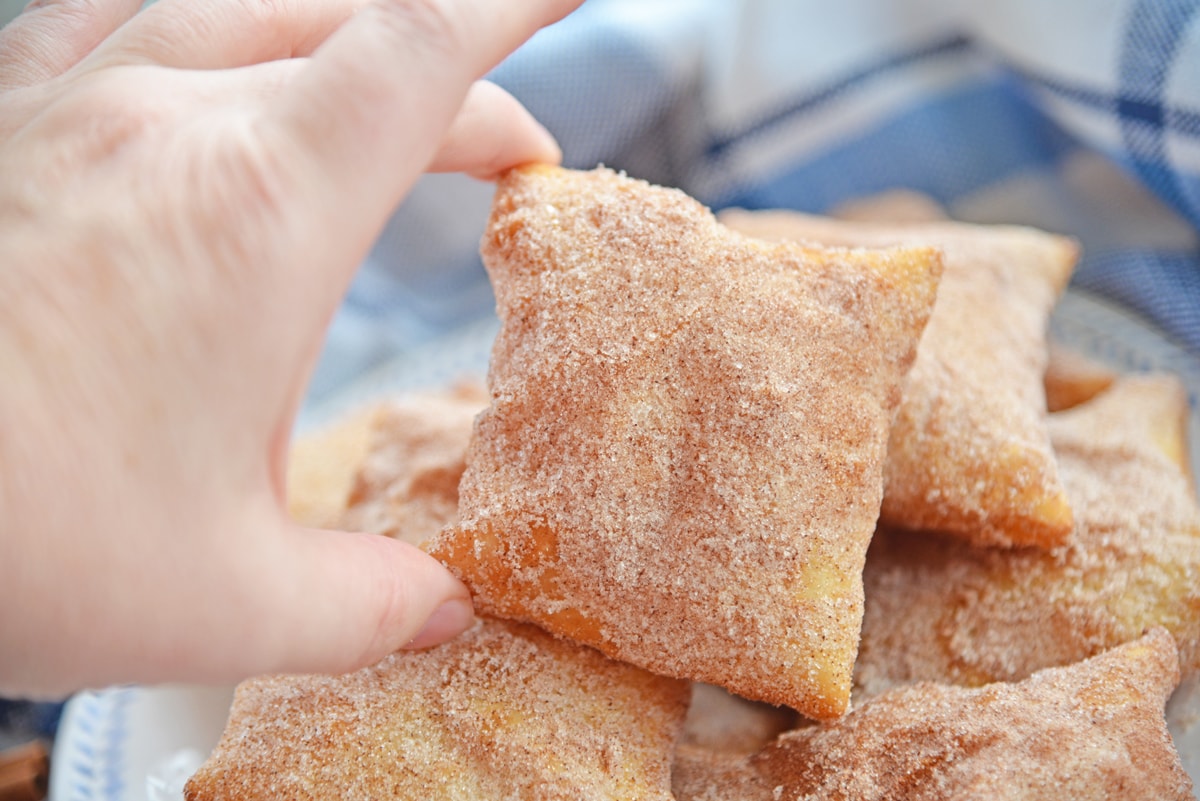 hand reaching in for a sopapilla 