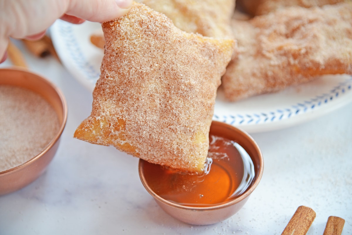 dipping a sopapilla dipping in honey 