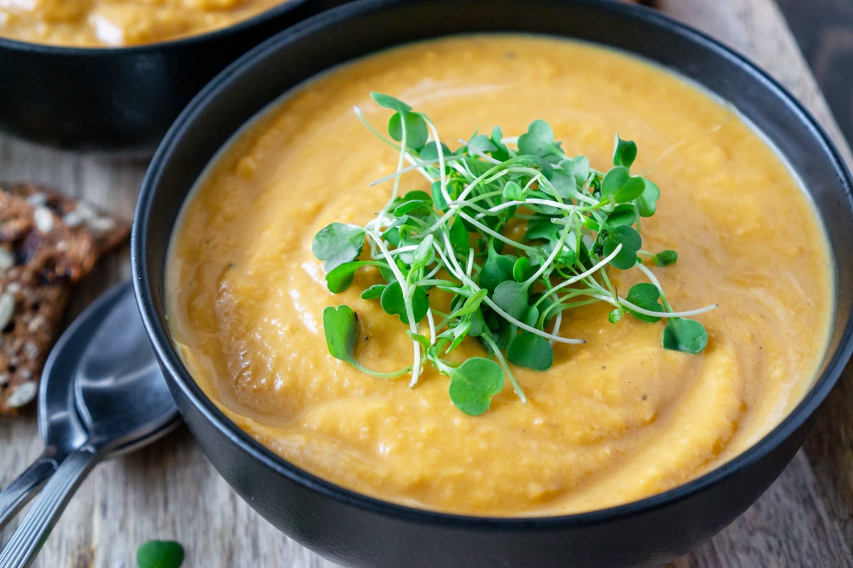 angle of easy butternut squash soup garnished with microgreens