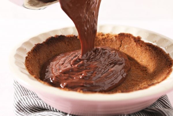 pouring chocolate pudding into crust