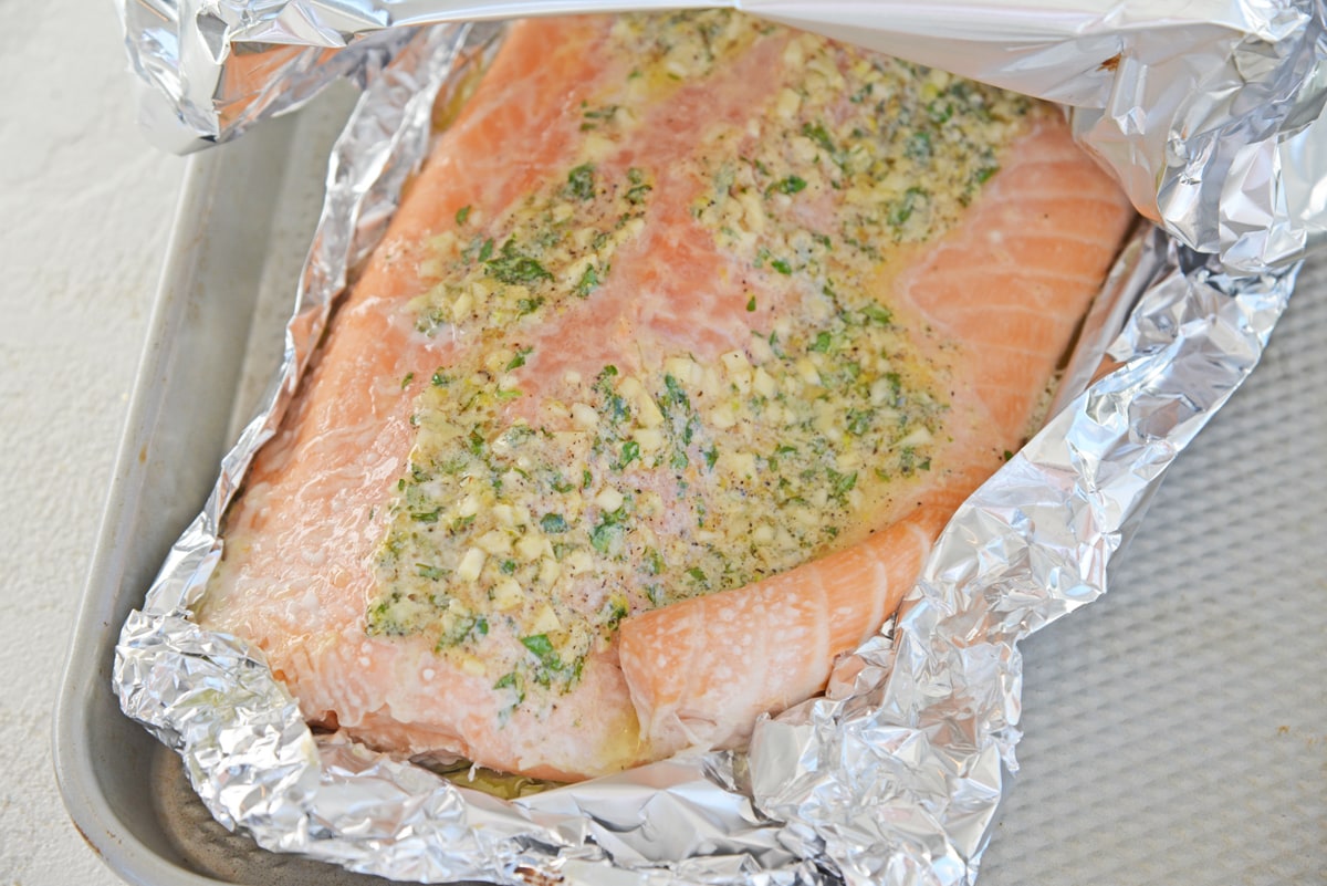 unwrapping salmon baked in aluminum foil 