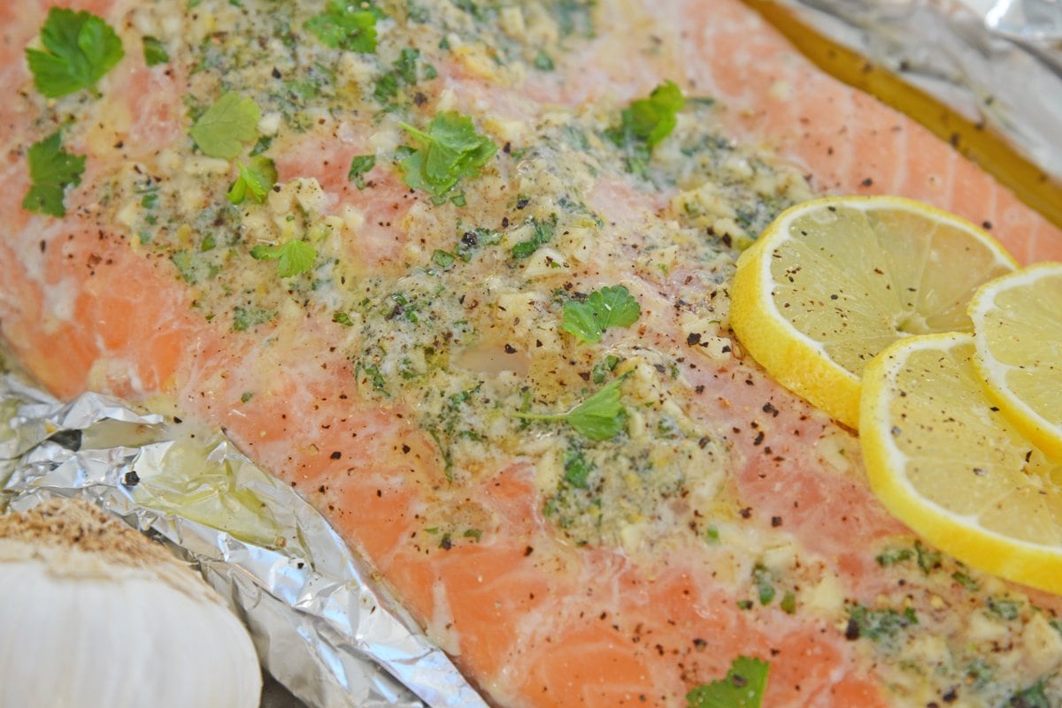 close up of melted garlic butter on baked salmon 