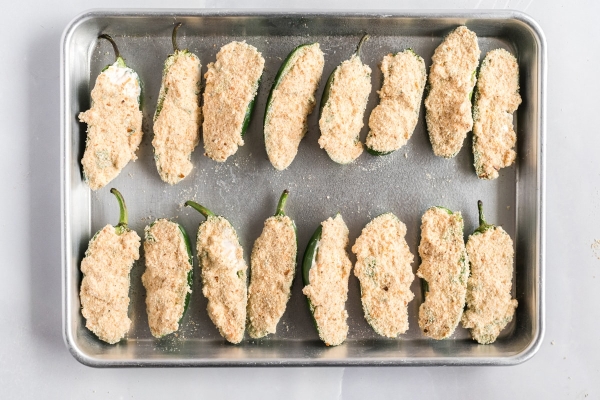 stuffed jalapenos on a baking sheet