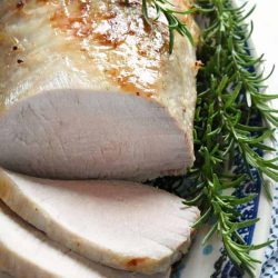 angled shot of sliced pork loin with rosemary