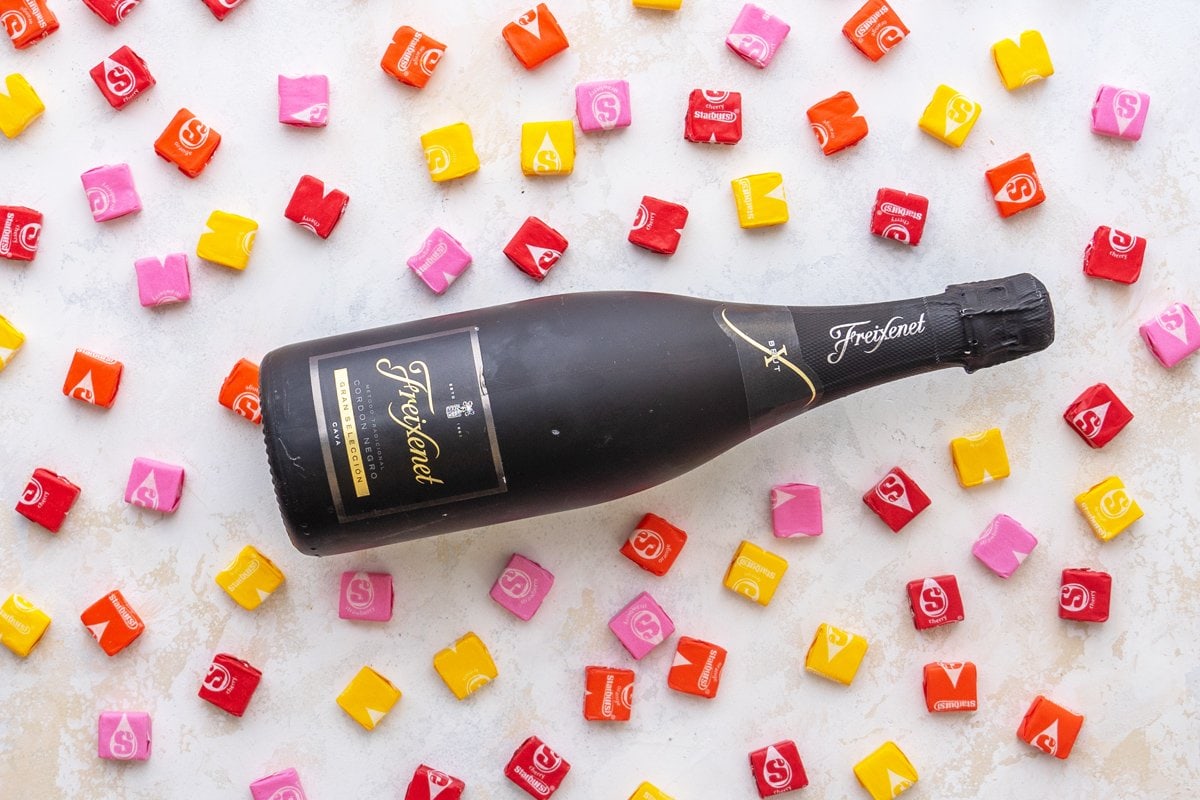 sparkling wine bottle surrounded by starburst candy 