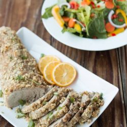 pork tenderloin on white platter with lemon slices