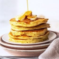 syrup pouring over a stack of banana pancakes