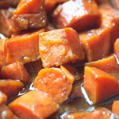 close up angled shot of candied sweet potatoes in pan