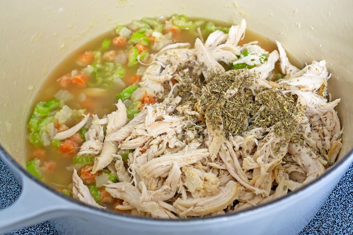 cooked chicken going into a soup base