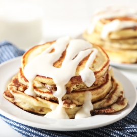 stack of cinnamon roll pancakes with icing drizzle
