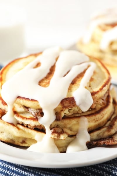 stack of cinnamon roll pancakes with icing drizzle