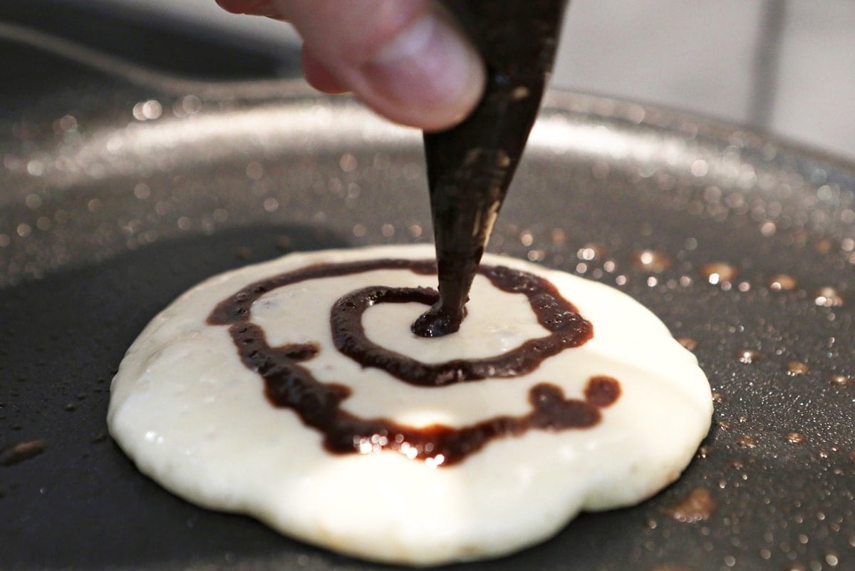 making a cinnamon swirl on pancakes