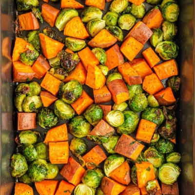 overhead shot of brussels sprouts and sweet potatoes on sheet pan