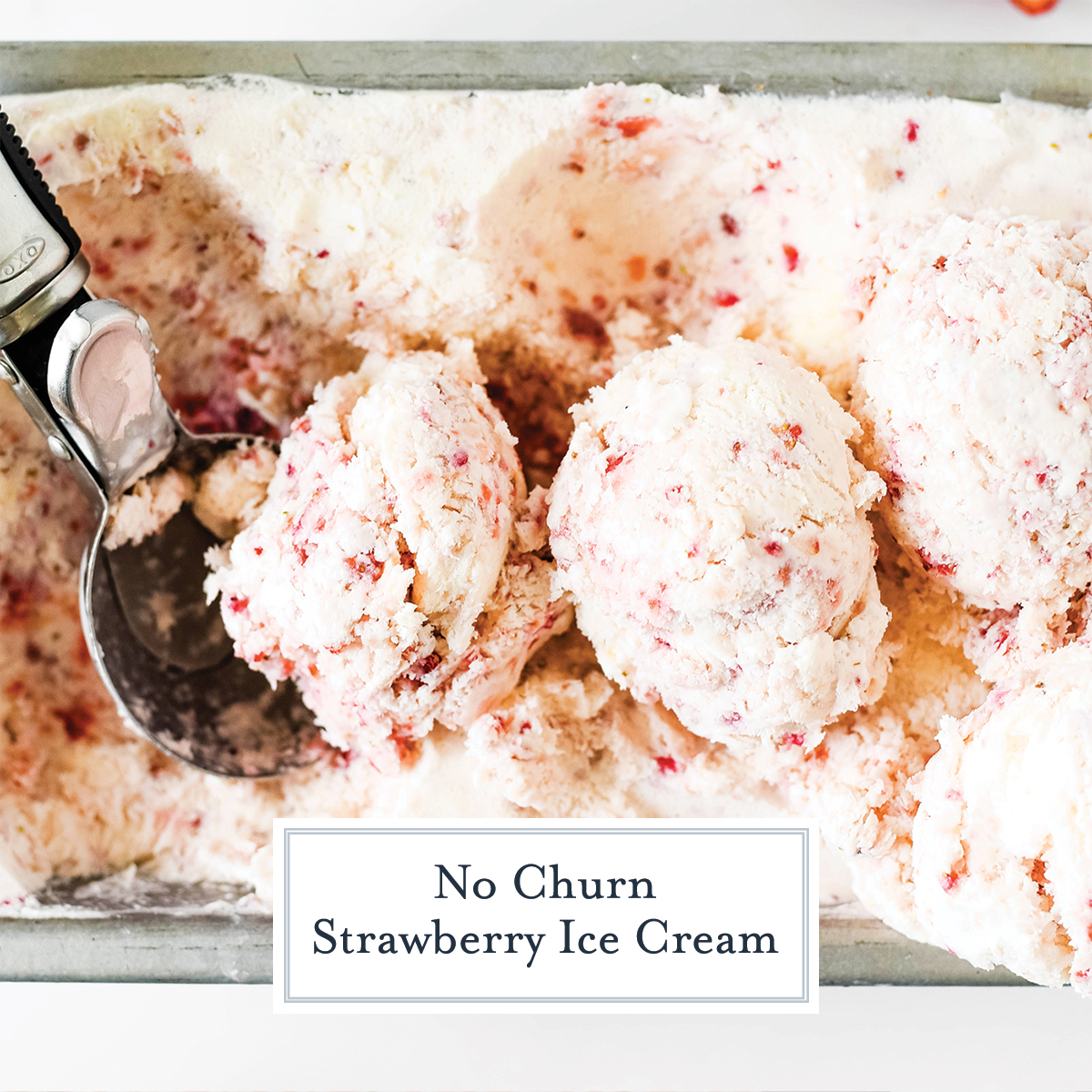 close up scooping strawberry ice cream from a loaf pan 