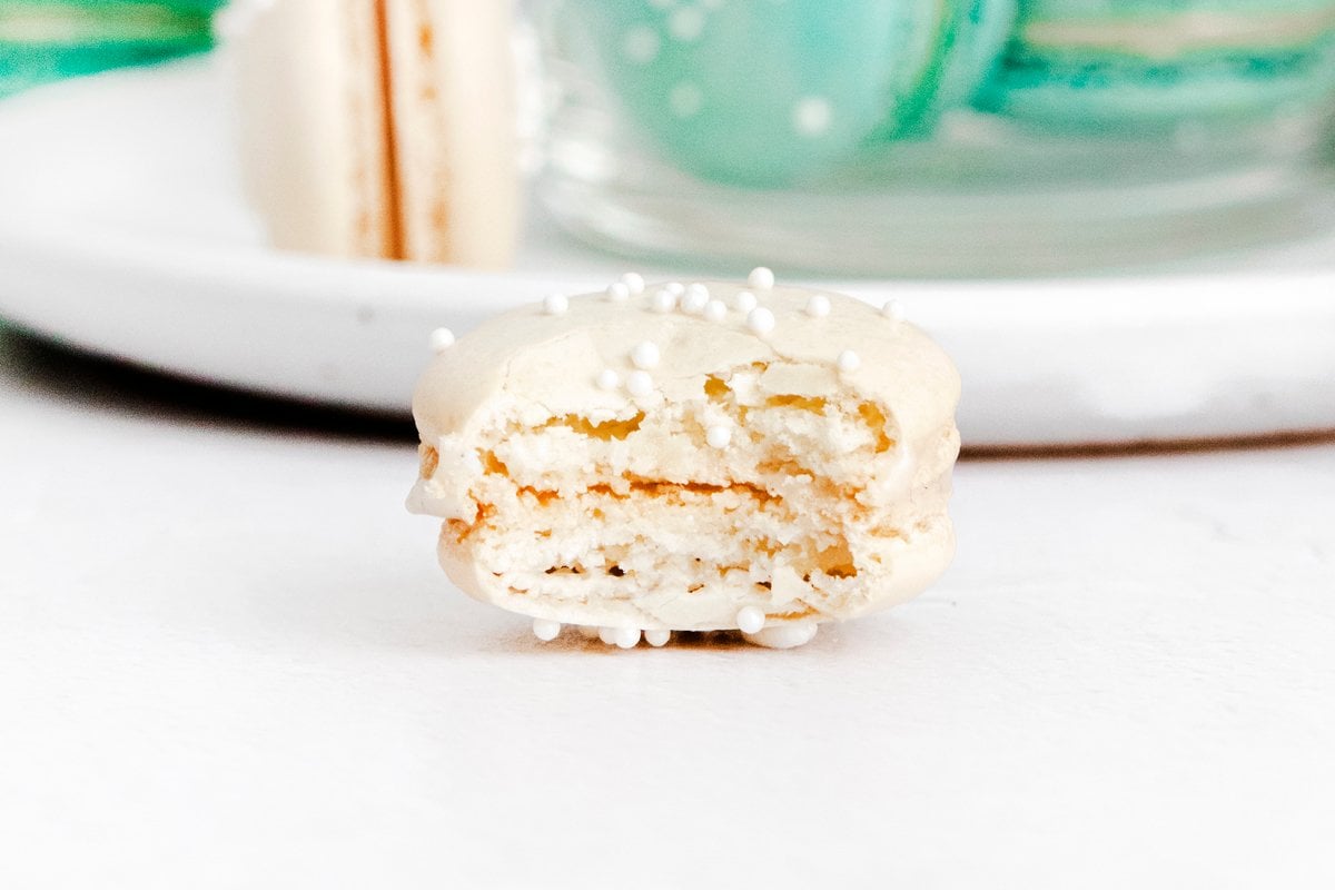 vanilla macaron with a bite out of it 