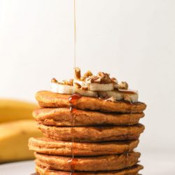 stack of sweet potato pancakes with syrup dripping