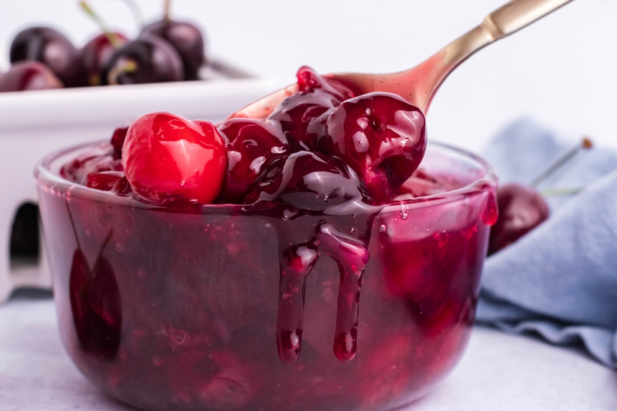 spoon dipping into a bowl of cherries 