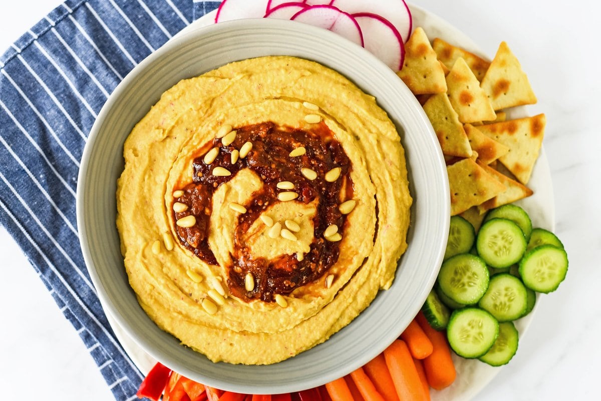 overhead of spicy hummus in a bowl with veggies 