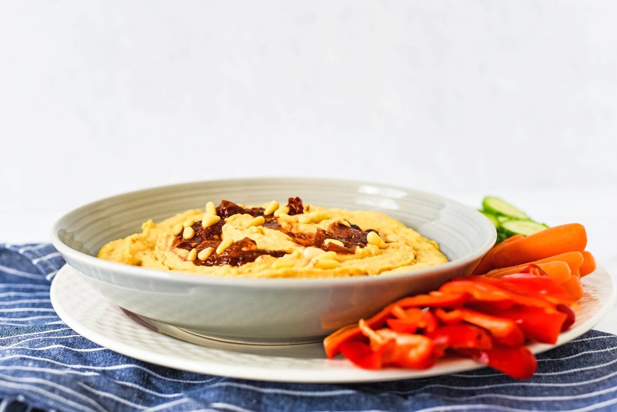 angle view of spicy hummus with crudites in a bowl 