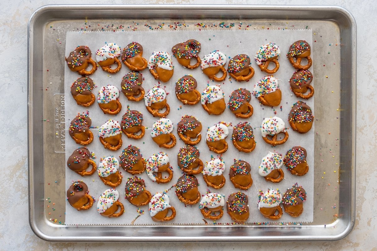 baking sheet of chocolate caramel pretzels with rainbow sprinkles 