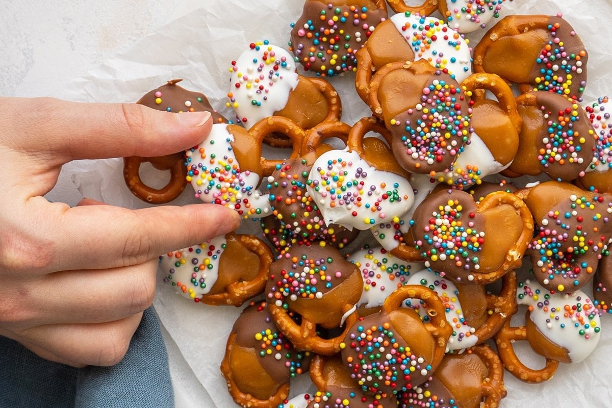 hand reaching for chocolate covered pretzels 