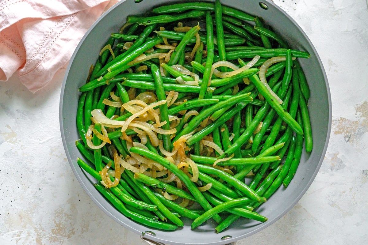 green beans and onions in a skillet 