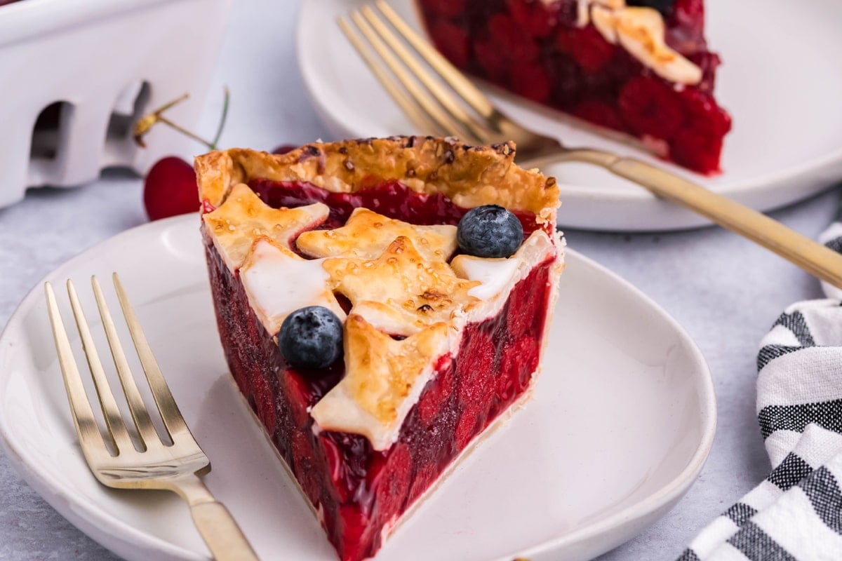 slice of red, white and blue cherry pie on a white plate 