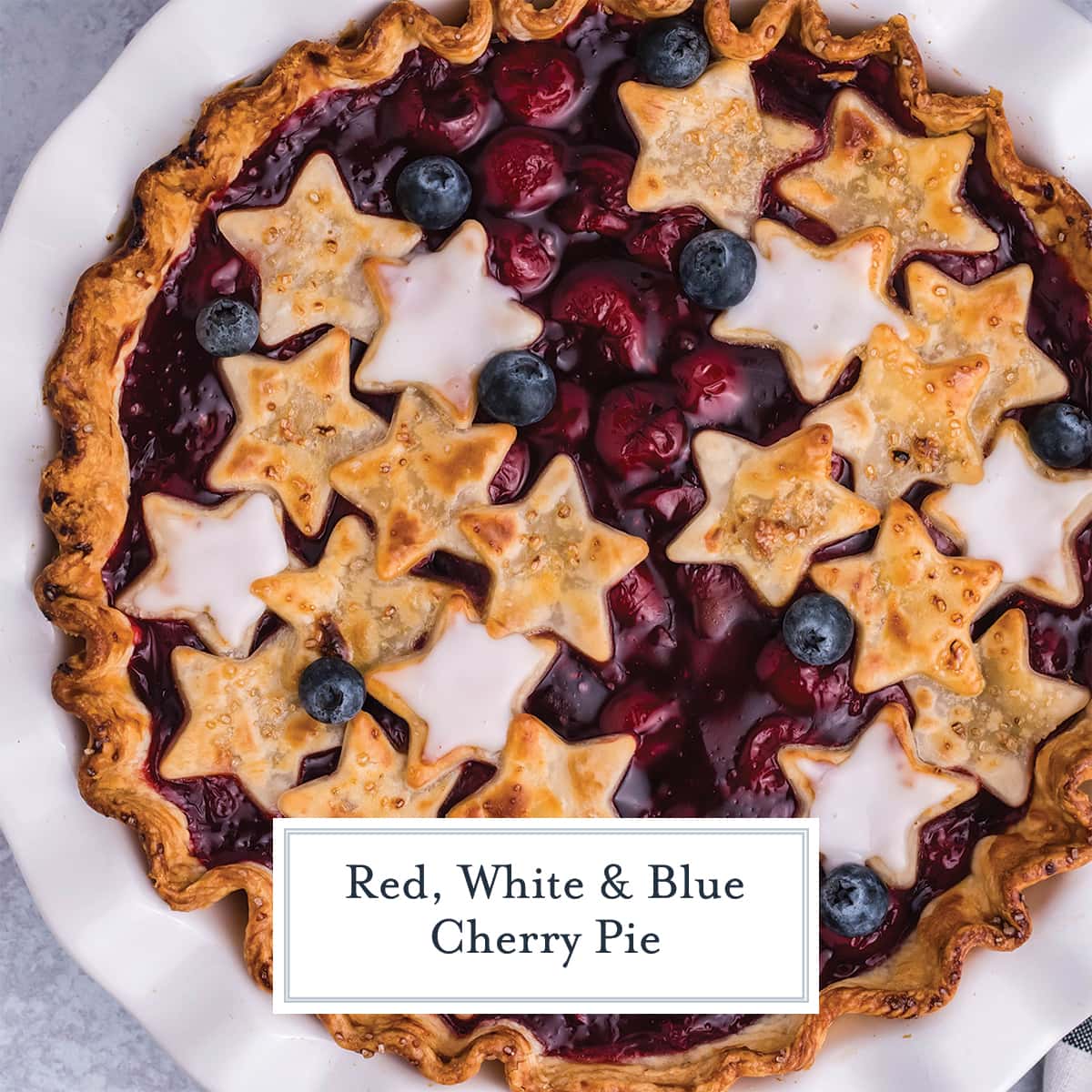 overhead of a cherry pie with stars and blueberries