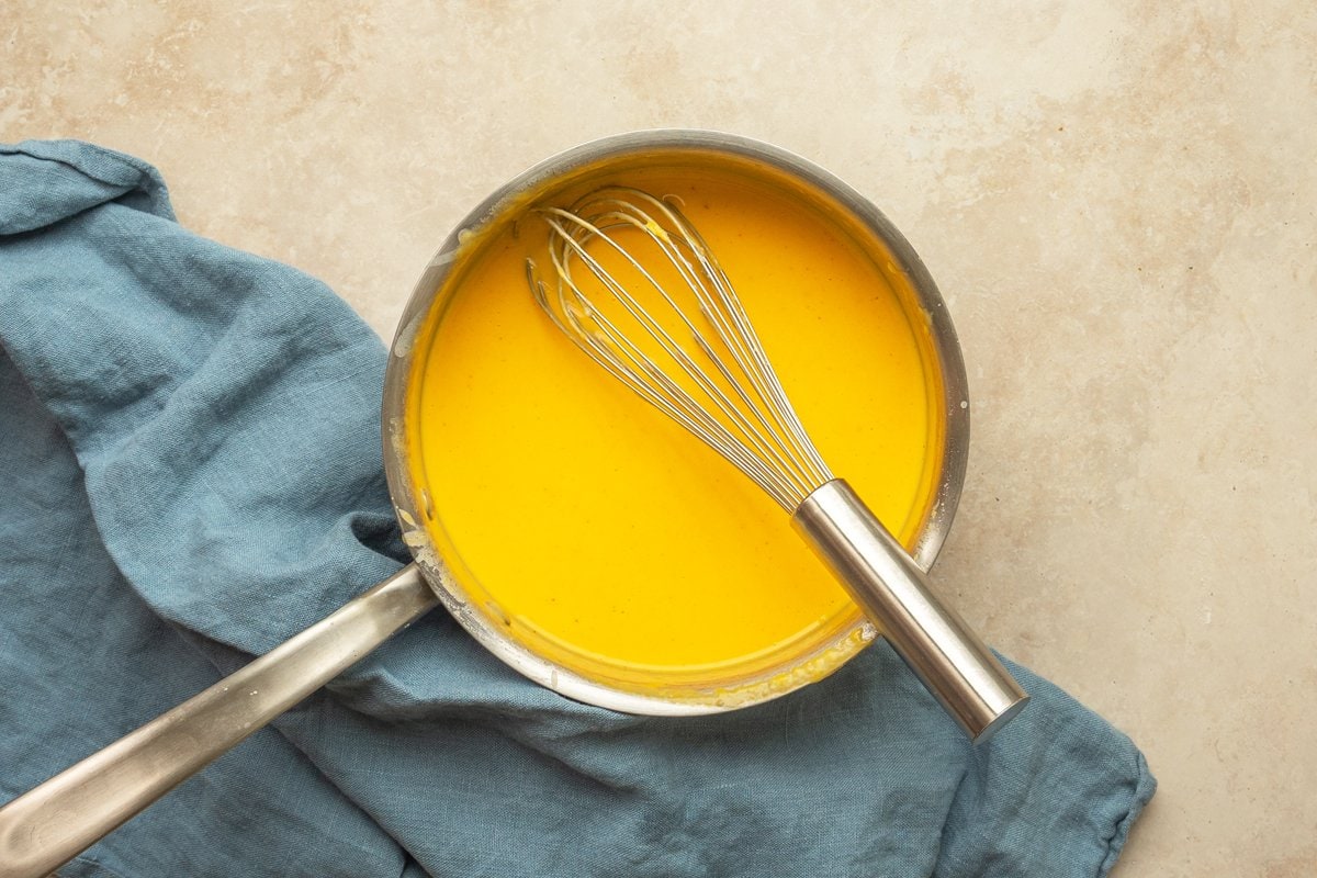 cheese sauce in a saucepan with a whisk 