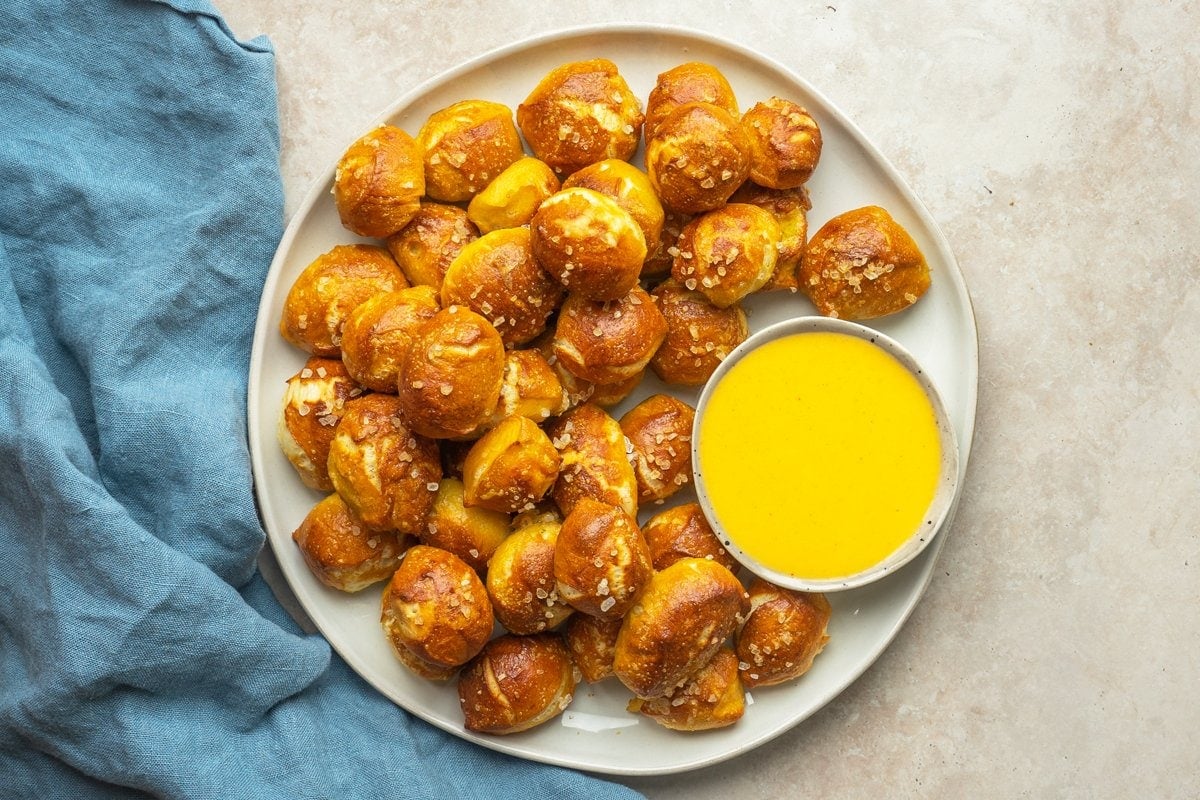 overhead of soft pretzel bites with cheese sauce