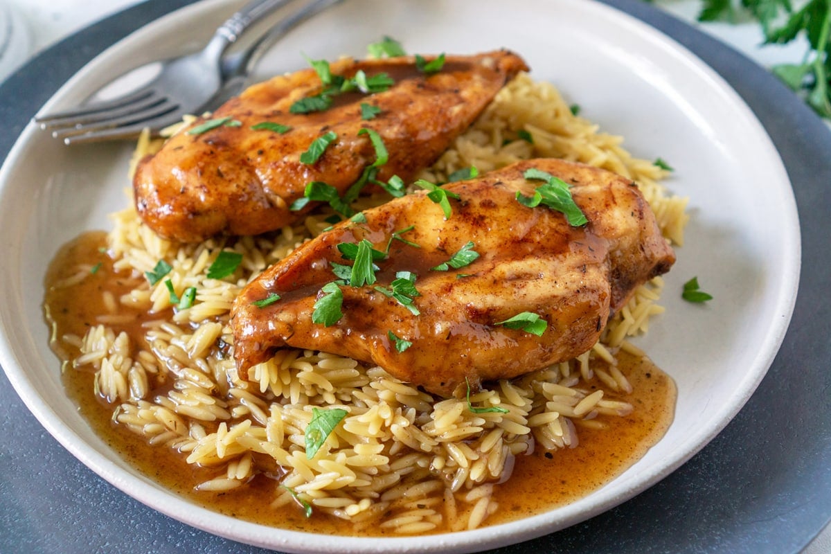 close up of chicken in a plate over rice 