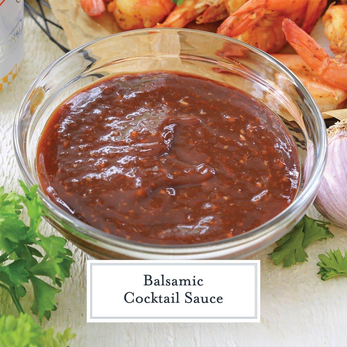 close up bowl of cocktail sauce with fresh herbs and shrimp 